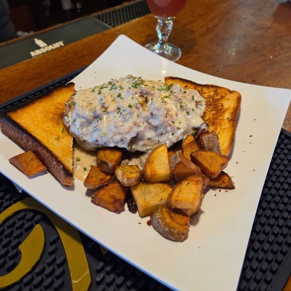 Chicken fried steak with gravy, toast, and home fries on a white plate at Frosty's Good Food & Fine Spirits.