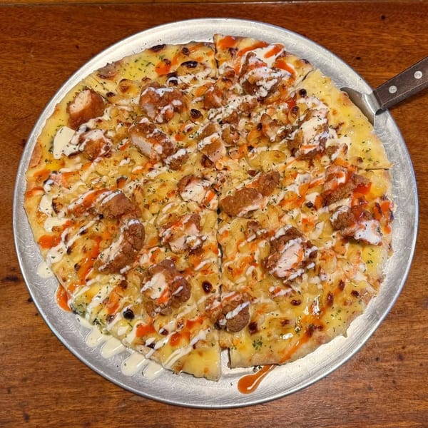 A Frosty's Good Food & Fine Spirits pizza with fried chicken, mac and cheese, and sauces.